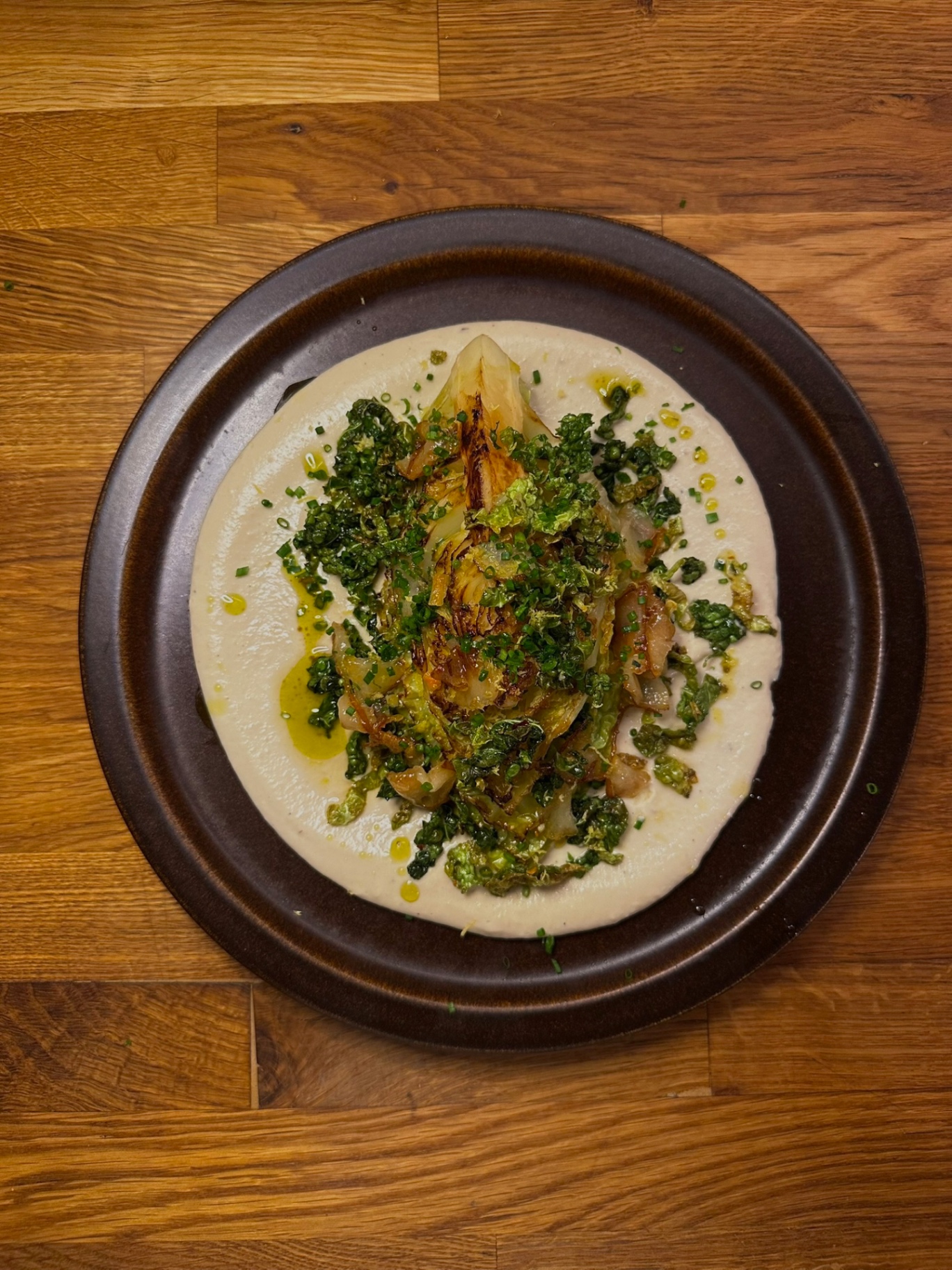 Charred hispi cabbage on white-bean purée with kale gremolata