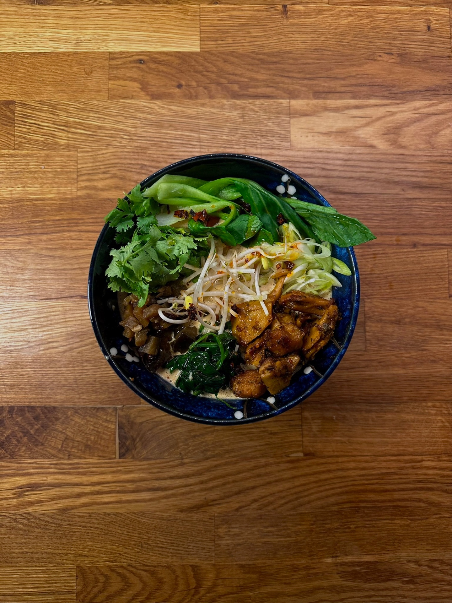 Coconut ramen with pak choi, glazed mushrooms, sprouts and fresh herbs
